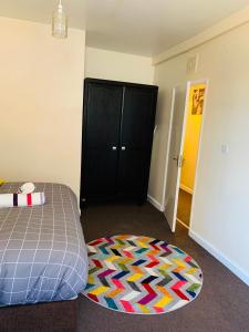 1 dormitorio con cama, armario negro y alfombra en Pine Lodge en Gillingham