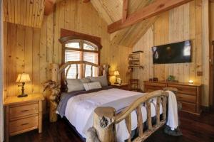 een slaapkamer met een bed in een kamer met houten wanden bij Carriage House On The Stream Sundance, Utah in Sundance