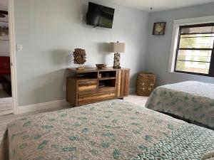 Un dormitorio con dos camas y un televisor en la pared. en Escape to paradise, en St Pete Beach