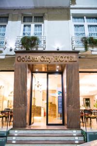 Golden City Hotel & Spa, Tirana في تيرانا: مدخل الفندق مع وجود لافتة فندق جولدن ستي