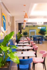 Golden City Hotel & Spa, Tirana في تيرانا: صف من الطاولات والكراسي في المطعم