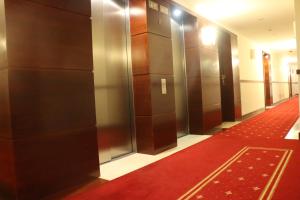 un couloir avec des ascenseurs et un tapis rouge dans l'établissement Center - Atelier Residence, à Varsovie