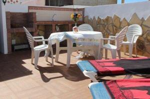 een tafel en stoelen met een witte tafel en een tafel en stoelen bij Casa María en el centro Nerja in Nerja