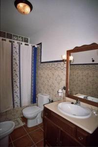 a bathroom with a sink and a toilet and a mirror at Casa María en el centro Nerja in Nerja