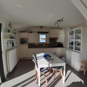 a kitchen with a white table and chairs at Maison Maritime in Middelkerke