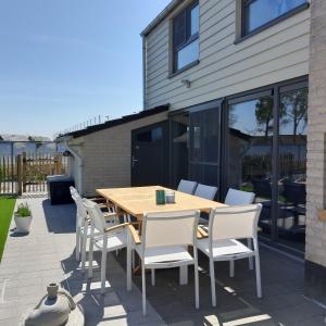 een houten tafel en stoelen op een patio bij Maison Maritime in Middelkerke