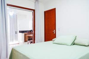 - une chambre avec un lit blanc et une fenêtre dans l'établissement RESIDENCIAL FLATS ANGELIM I - TÉRREO , 2 QUARTOS com AR, CENTRO, à Itacaré