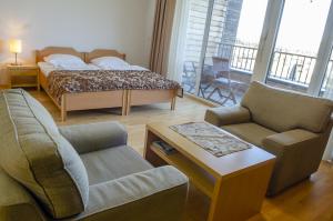Villa Mari I في ماريبور: غرفة معيشة مع سرير وأريكة وكراسي