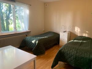 Pokój z 2 łóżkami, stołem i oknem w obiekcie Lilla Huset på Slätten B&B w mieście Lund