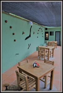 uma sala com mesas e uma parede com um mural de pinguim em El Amate em Tepoztlán