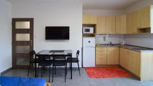 eine Küche mit einem Tisch und Stühlen sowie einem weißen Kühlschrank in der Unterkunft Apartman Veronika in Trojanovice