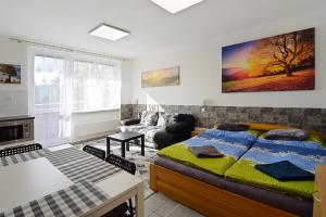 a bedroom with a bed and a living room at Apartman Nikola Trojanovice in Trojanovice