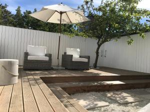 a patio with two chairs and an umbrella at Sjøgata Gjestehus No1 in Larvik