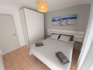 una camera con un grande letto bianco di Apartamentos Sarah a Morro del Jable