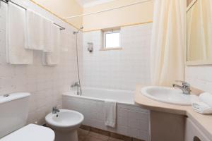 a bathroom with a sink and a tub and a toilet at Hotel Rural Monte da Leziria in Santo André