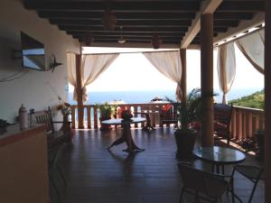 Playa Estacahuite的住宿－Gloria's Hotel，一位在门廊上散步的海景女性