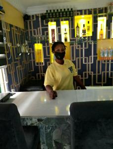 a man wearing a mask standing behind a table at StayCation Suites And Apartment in Lagos