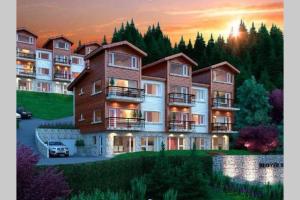 a large apartment building with a sunset in the background at "Corazon al sur" departamento con vista única al Huapi in San Carlos de Bariloche