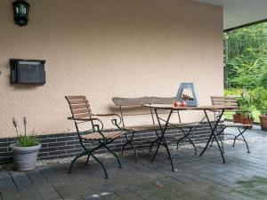 a table and chairs sitting next to a wall at Holiday home in Kyllburg Eifel near the forest in Kyllburg