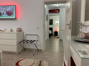 a white kitchen with a chair and a table at Luxury Apartment in Galaţi