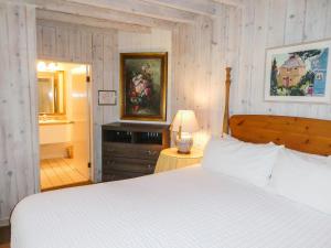 a bedroom with a white bed and a bathroom at Briarwood Inn in Carmel