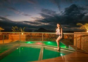 a woman standing on the edge of a swimming pool at Hotel Marcoantonio - Moyobamba in Moyobamba