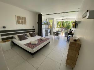 ein Schlafzimmer mit einem Bett und eine Küche mit einem Balkon in der Unterkunft Iguana studio vue mer avec cuve in Saint-François