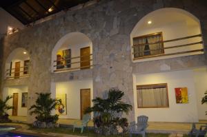un edificio con ventanas arqueadas y una pared de piedra. en Axkan Arte Hotel Tuxtla en Tuxtla Gutiérrez