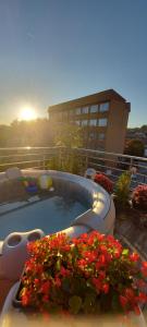 a hot tub with flowers on a balcony with a building at Villa Radica in Negotino