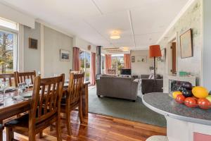 Il comprend une cuisine et un salon avec une table et des chaises. dans l'établissement Cedar Cottage - Tauranga Taupo Holiday Home, à Kuratau