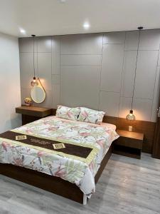a bedroom with a bed with a mirror and two tables at Khánh Phong Apartment in Waterfront in Hai Phong