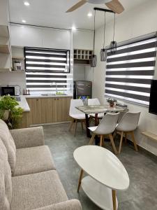 a living room with a couch and a table and chairs at Khánh Phong Apartment in Waterfront in Hai Phong