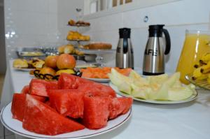 uma mesa com dois pratos de melancia e outros frutos em Hostel Prime em Rio Verde