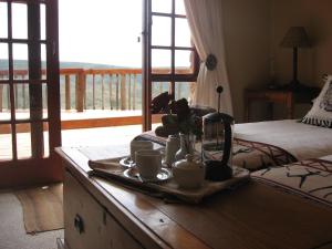 una bandeja de tazas de café en una mesa de un dormitorio en Intaba Lodge, en Kirkwood