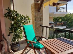 una sedia verde e un tavolo sul balcone di Ferienapartment At Home Ouranoupolis a Ouranoupoli