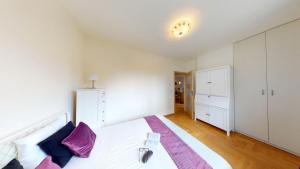 1 dormitorio con 1 cama blanca grande con almohadas moradas en Silent Apartment Center, en Varsovia