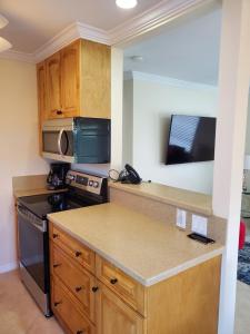 a kitchen with wooden cabinets and a counter top at Ocean Side Resort - updated Villa in Hillsboro Beach