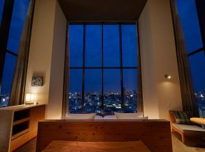 a room with a large window with a city view at HOTEL STRATA NAHA in Naha +99 photos