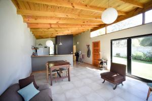 a living room with a wooden ceiling and a table at Casa Barrio Acantilados proxima al mar in Mar del Plata +12 photos