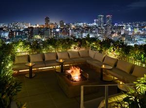 a living room with a couch and a fire pit at HOTEL STRATA NAHA in Naha