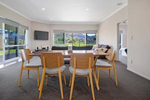 ein Esszimmer mit einem Tisch und Stühlen in der Unterkunft Sky Blue Retreat - Waihi Beach Holiday Home in Waihi Beach