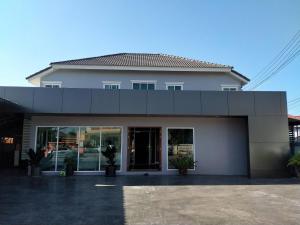 a white building with glass doors in front of it at Feelathome in Chiang Rai