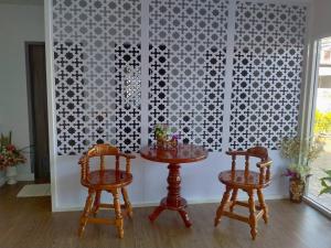 a dining room with two tables and two chairs at Feelathome in Chiang Rai