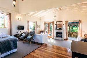 a bedroom with a bed and a living room with a fireplace at The Loft at Cypress Ridge Estate in Onetangi