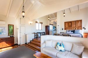 uma sala de estar com um sofá e uma cama em The Loft at Cypress Ridge Estate em Onetangi
