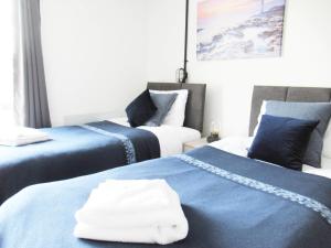 duas camas com toalhas num quarto em Queen Street Apartments em Wolverhampton