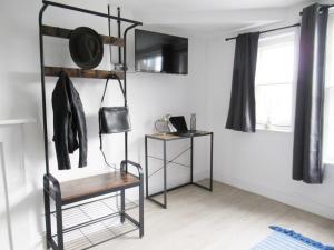 um quarto com uma cadeira, uma mesa e uma janela em Queen Street Apartments em Wolverhampton