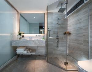 La salle de bains est pourvue d'une douche et d'un lavabo. dans l'établissement Sentosa Hotel Apartment Taoyuan Branch, à Shenzhen