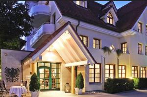 une grande maison blanche avec une table en face dans l'établissement Hotel Adler, à Aalen