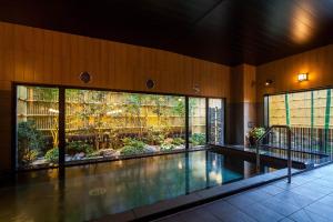 a swimming pool in a building with a garden at Hotel Route-Inn Tsuyama Ekimae in Tuyama
